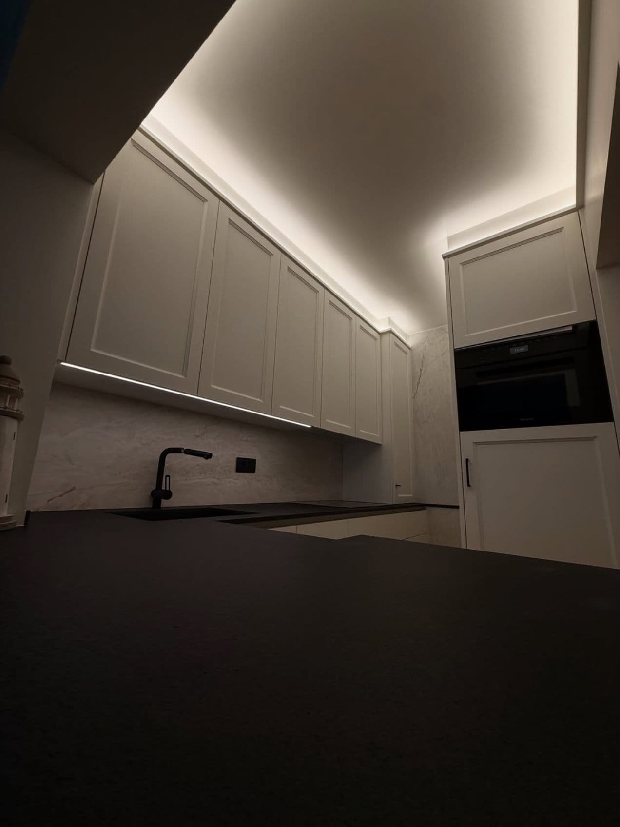 Keuken met indirecte verlichting boven de kasten en ledstrip onder de bovenkasten